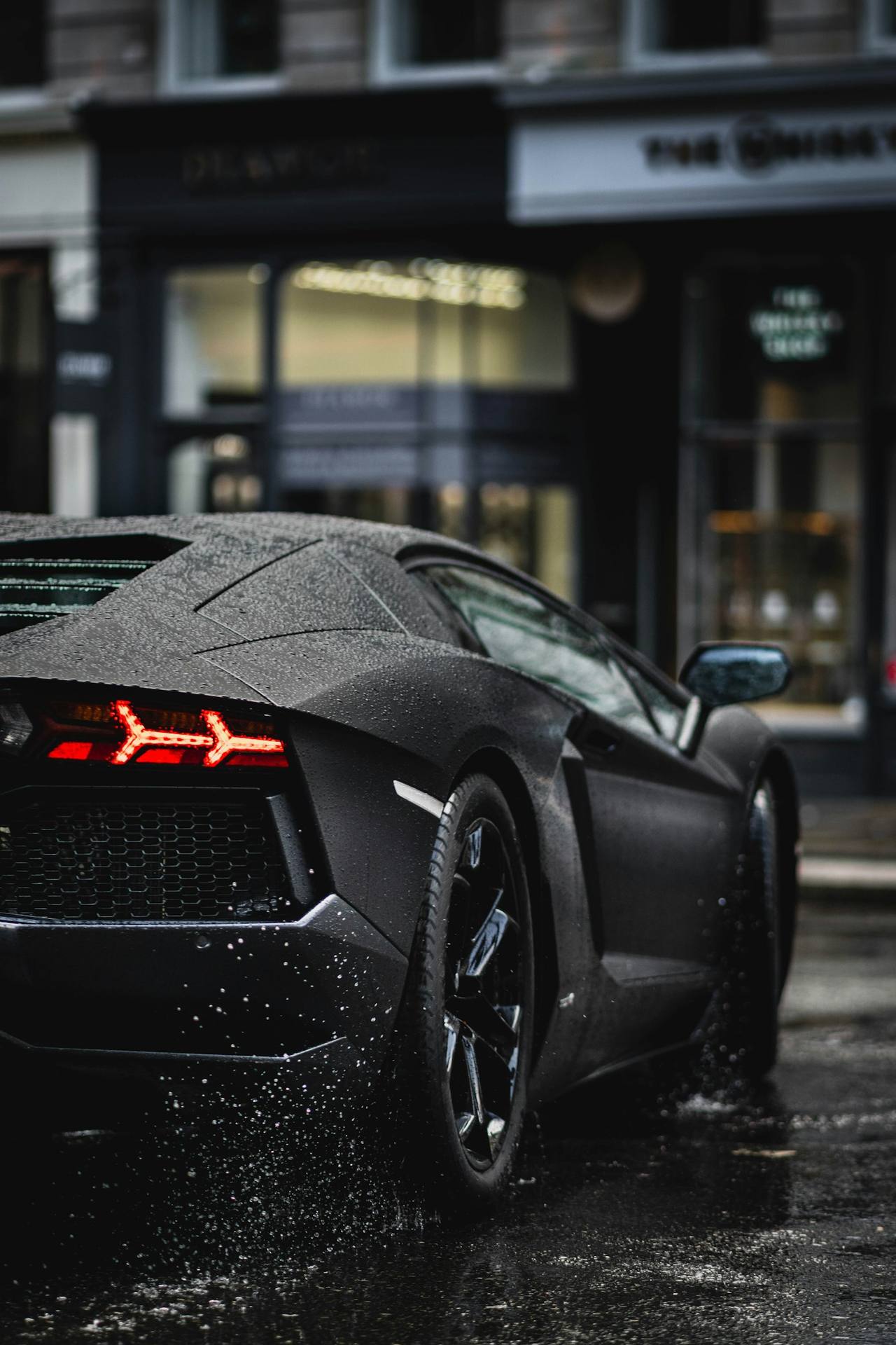 Matte black car on a wet street at night