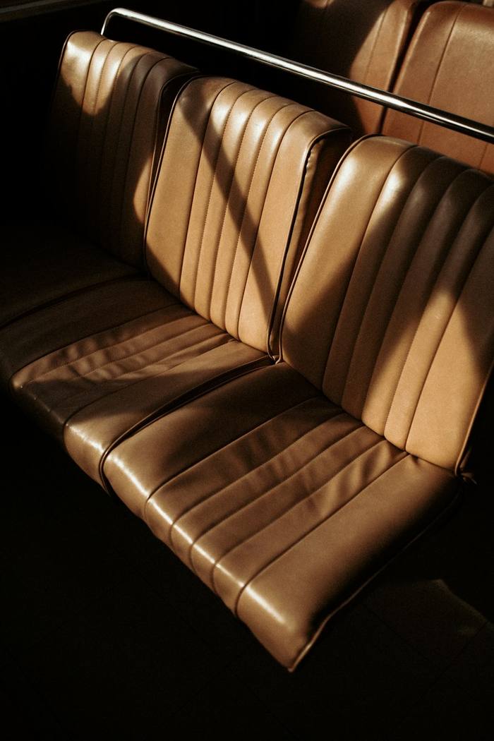 Pleated tan leather bench seat in raking light