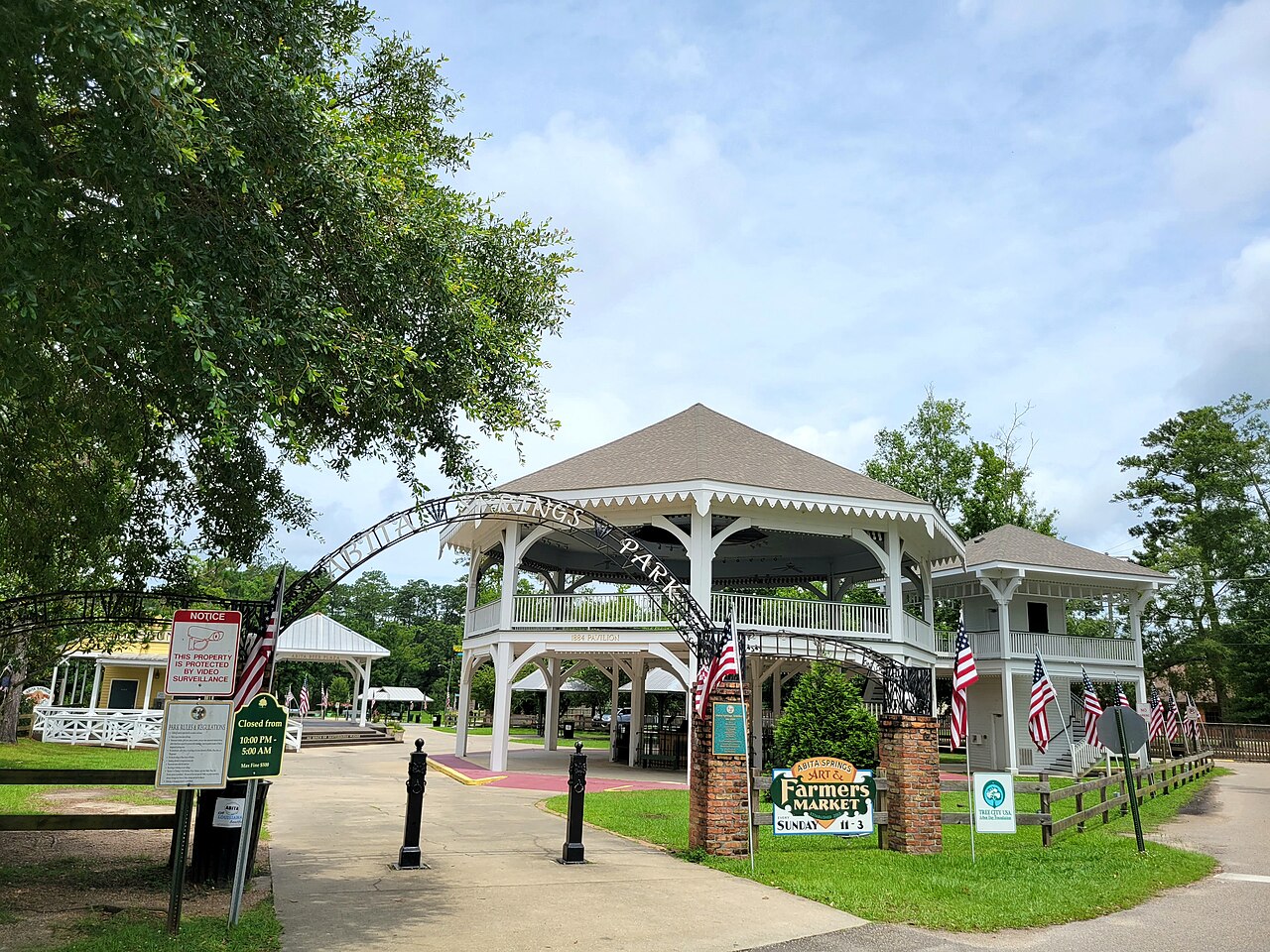 The Abita Springs pavilion behind the park arch, with the Sunday Art and Farmers Market sign