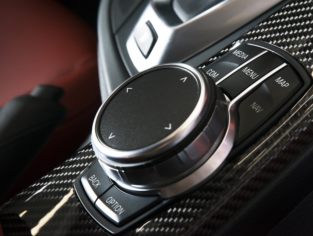 Rotary media and navigation controller on a carbon-trimmed center console